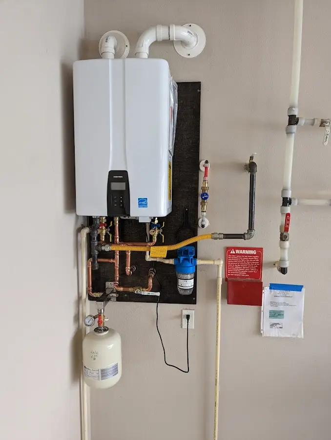 Professional plumber installing copper piping in a Logan home